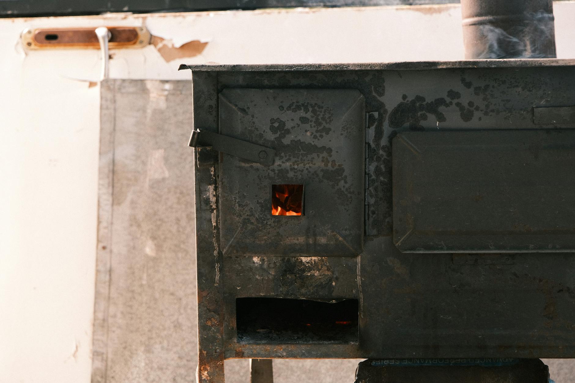 Zbliżenie na żeliwny piec z widocznym palącym się ogniem