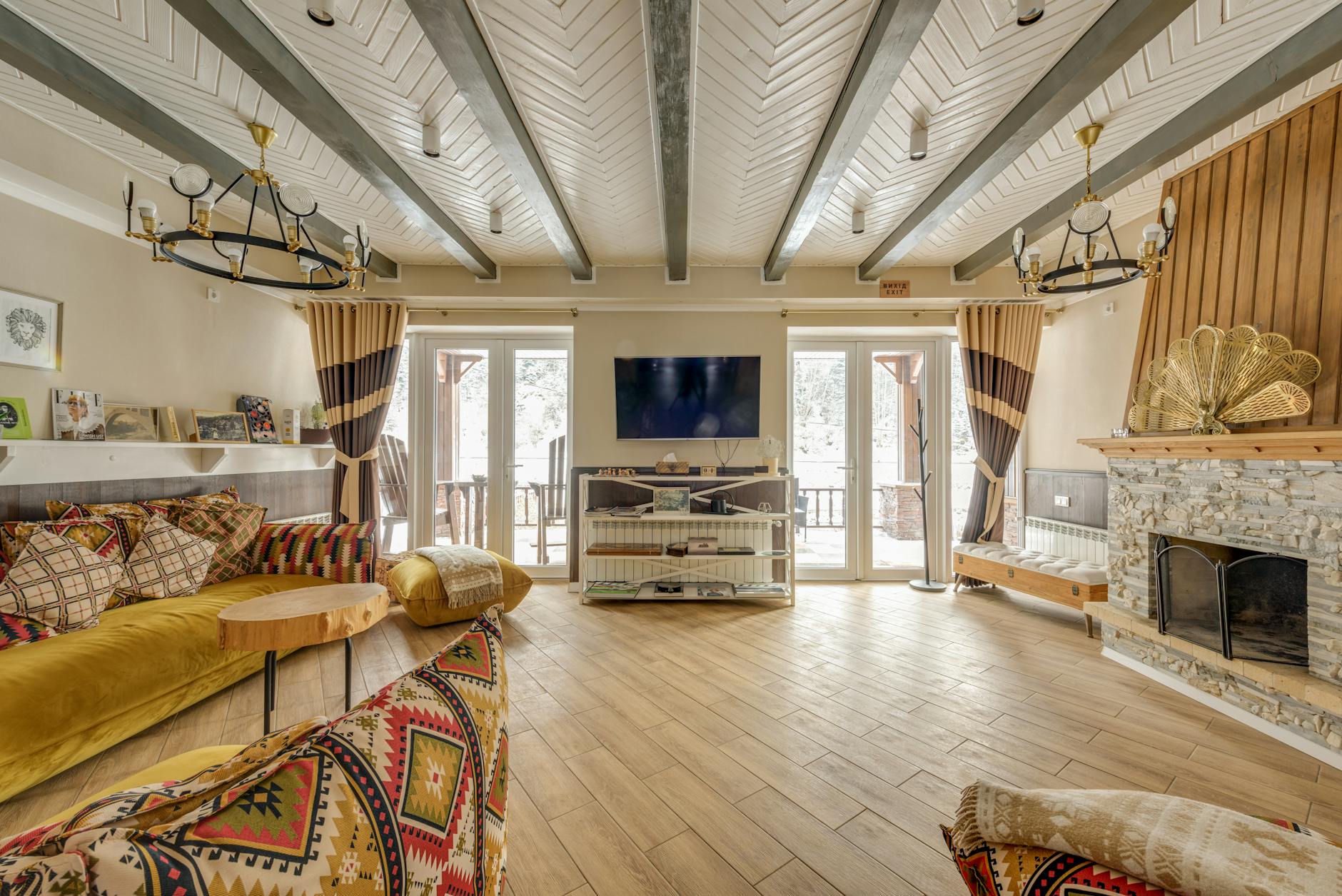 Rustykalny salon chalet z dużym kamiennym kominkiem i przytulnym wnętrzem