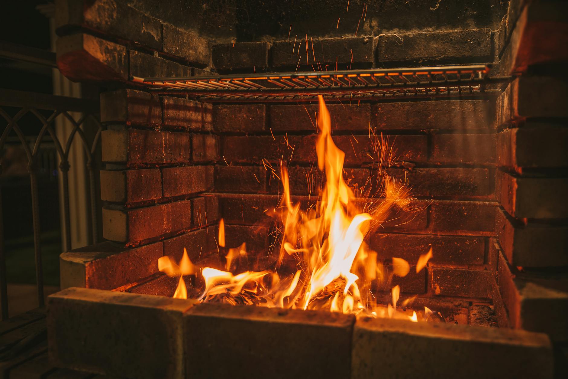Rozpalony wkład kominkowy w ceglanej obudowie w przytulnym salonie