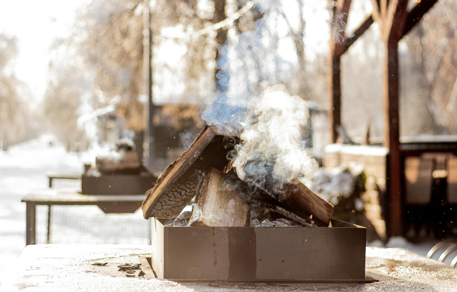 Wyciek dymu z obudowy kominka: diagnostyka nieszczelności i naprawa Zadymiony kominek ogrodowy palący się zimą na śniegu