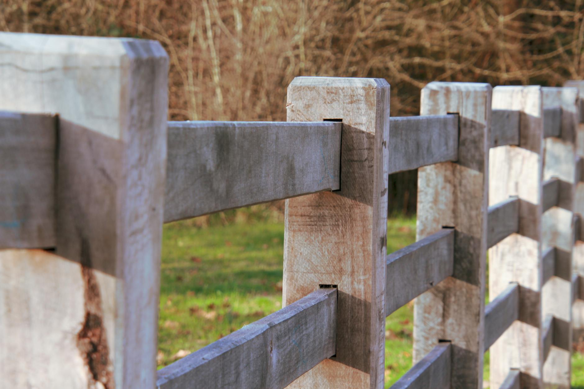 Zbliżenie drewnianego ogrodzenia na tle rozmytej zieleni