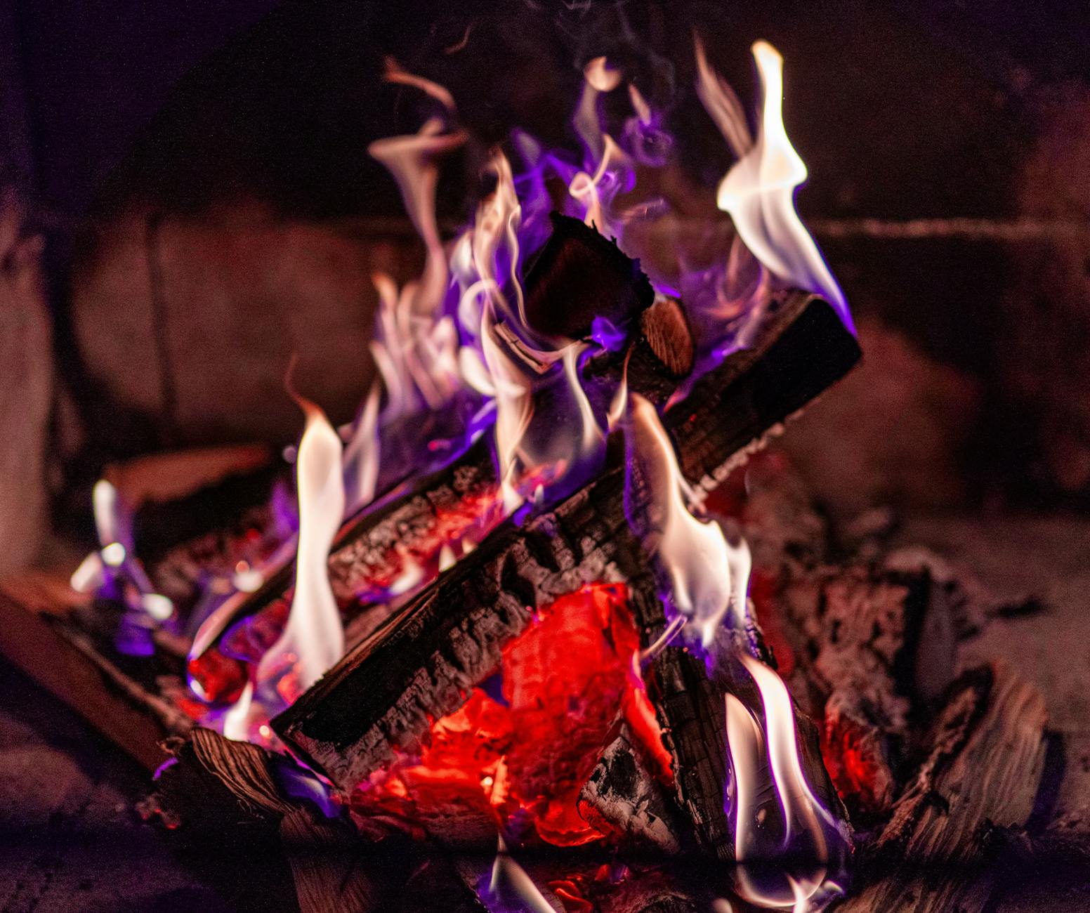 Zbliżenie na palące się polana i płomienie w kominku