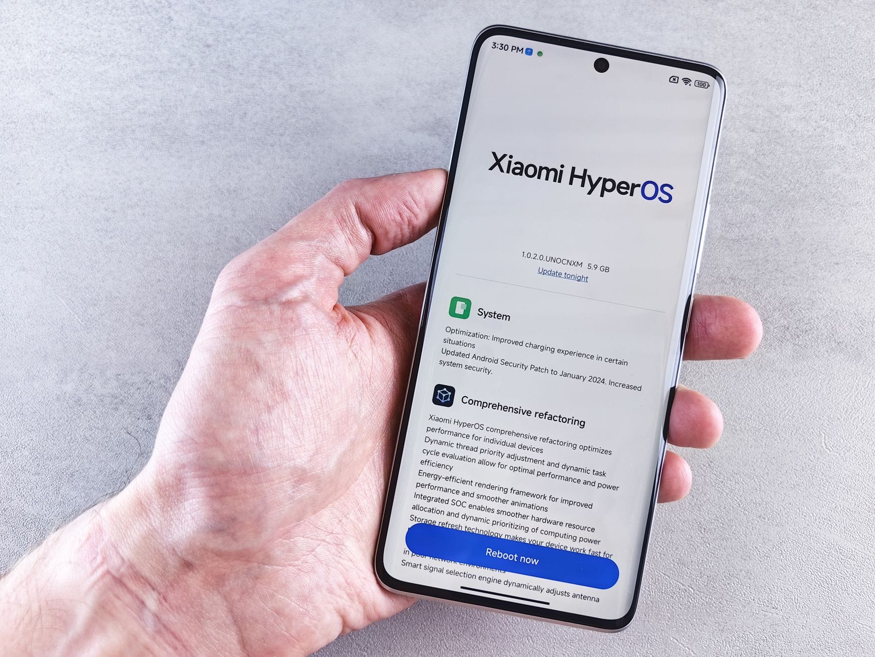 Dłoń trzymająca smartfon Xiaomi z ekranem ustawień systemu HyperOS
