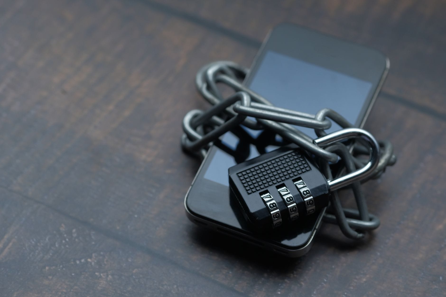 Smartfon opleciony łańcuchem z kłódką symbolizujący ochronę danych